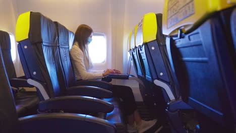 mujer trabajando en una computadora portátil en un avión