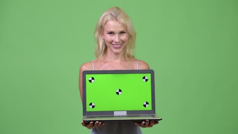 young happy beautiful businesswoman showing laptop