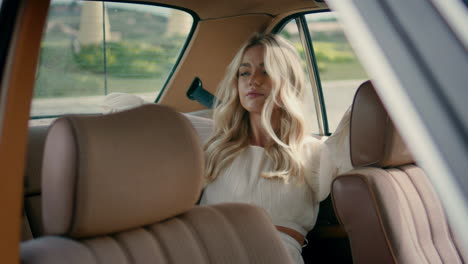 girl tourist posing auto backseat in white dress close up. woman sitting car