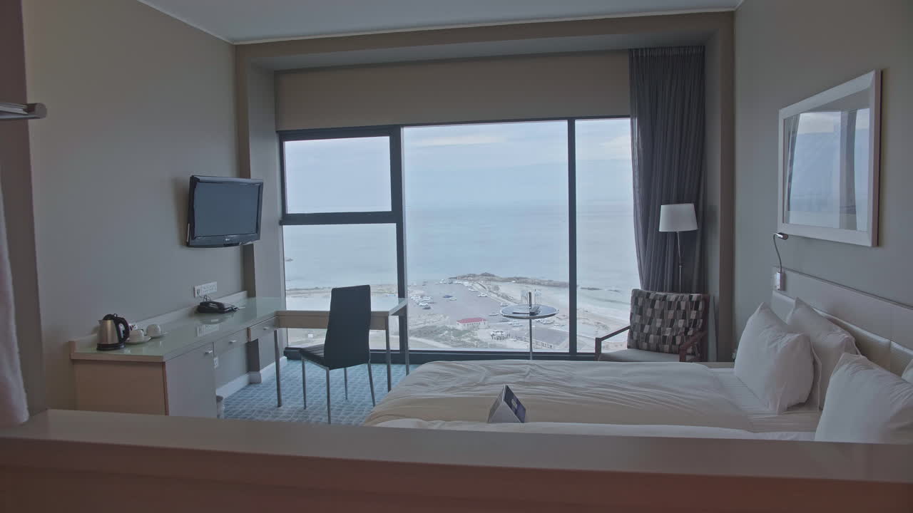 Gezellige hotelkamer met wit bed, uitzicht op zee, Zuid-Afrika