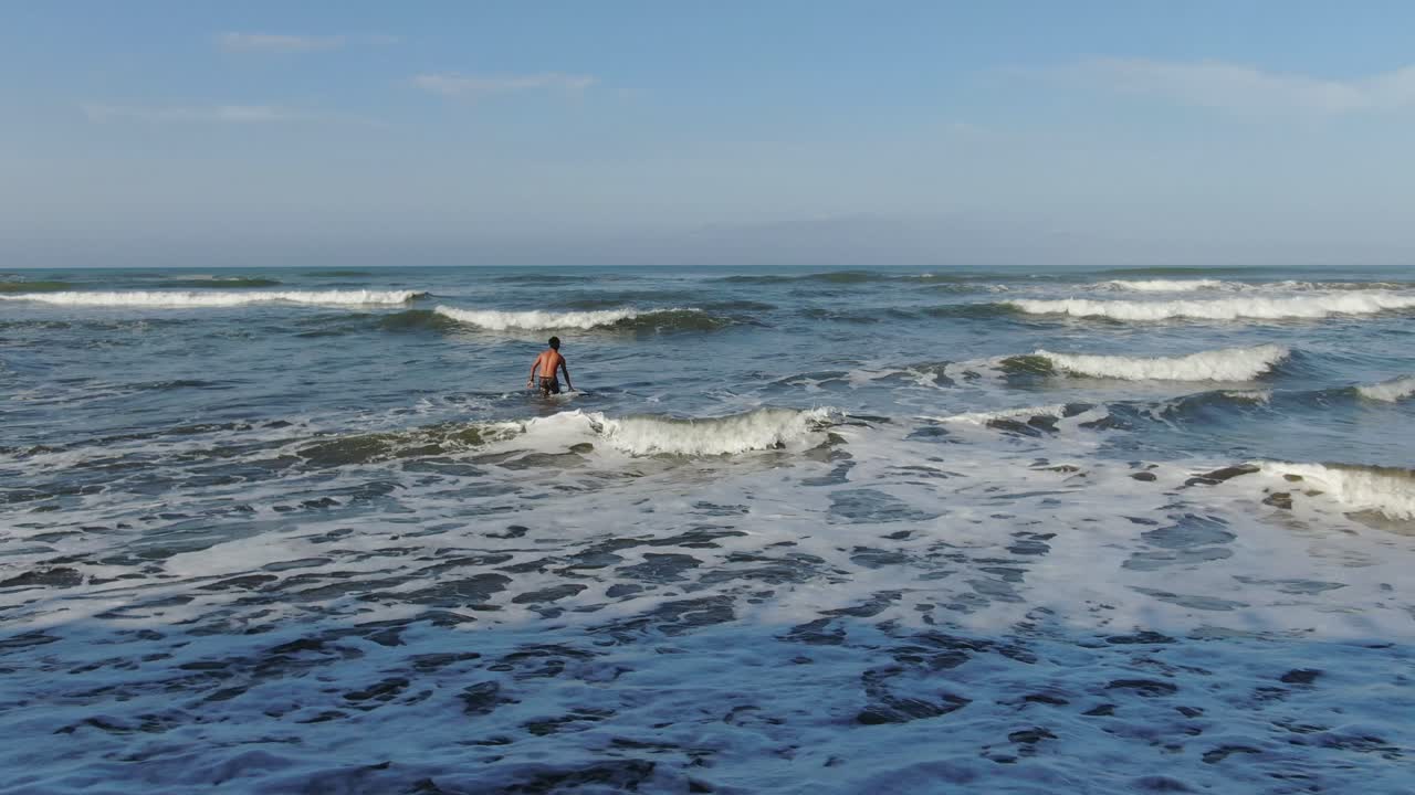 파도를 잡으려고 쿠잉하는 젊은 서퍼