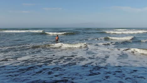 un joven surfista arrullándose para atrapar olas