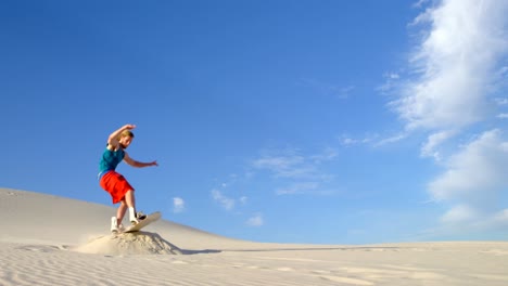 Man-performing-a-jump-while-sand-boarding-4k