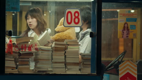 asian girls hang out and play in book store with cuddly teddy bear