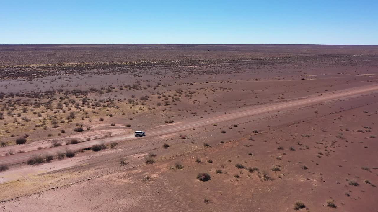 un auto conduciendo rápido por el desierto rojo de namibia, girando en la arena