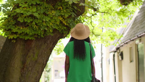 vista trasera de una turista femenina de vacaciones en oxford, reino unido, explorando la calle de la ciudad caminando a lo largo del pasaje lamb and flag 3