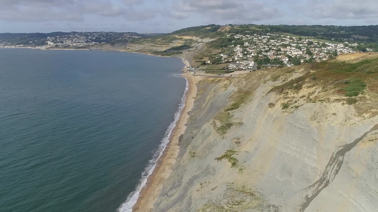 seguimiento aéreo sobre la costa jurásica hacia el pueblo de charmouth, dorset