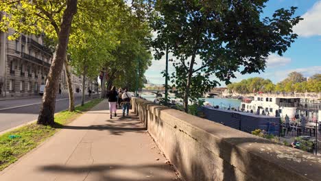a sunny day walking along the seine river in paris