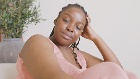 Close-Up-View-Of-Woman-Sitting-On-Sofa-Smiling-And-Looking-At-Camera