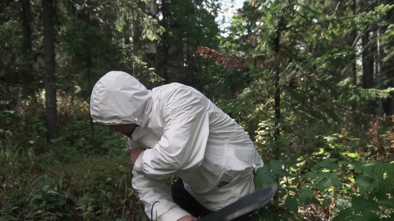 hombre con una chaqueta blanca caminando en el bosque