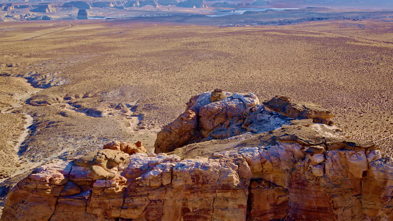 Drone shot panning up from interesting rockformation to reveal lake Powell near Page Arizona