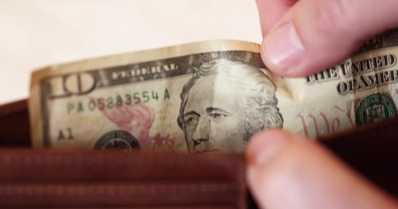 Momen cepat memeriksa uang kertas sepuluh dolar saat berada di dompet kulit cokelat untuk pengeluaran harian.