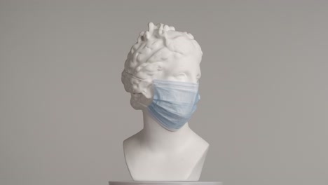 ancient bust wearing a face mask