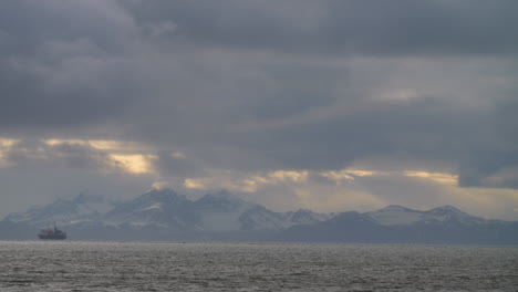 a timelapse of clouds against a backdrop of snow covered mountains