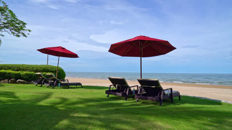 sombrilla roja y silla de playa con fondo de playa y cielo azul y luz solar