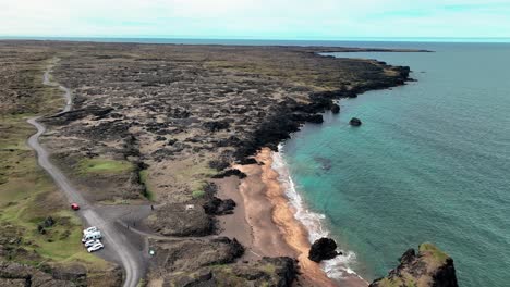 Luftaufnahme-Von-Autos,-Die-Auf-Der-Straße-In-Der-Nähe-Des-Strandes-Von-Skardsvik-Auf-Der-Halbinsel-Snaefellsnes,-Island,-Geparkt-Sind