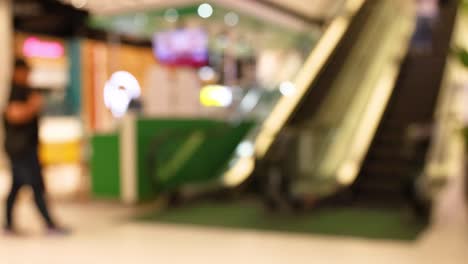 people moving around escalator in bangkok mall