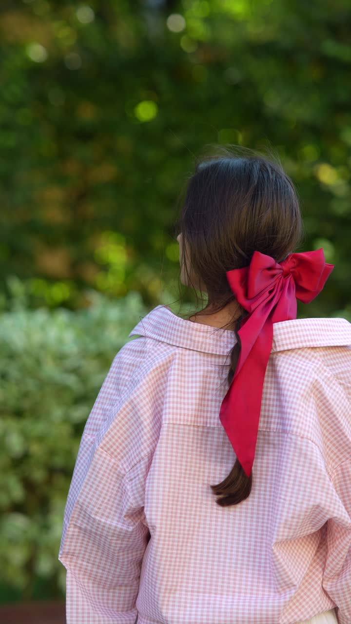 una mujer con un lazo rojo en el cabello.