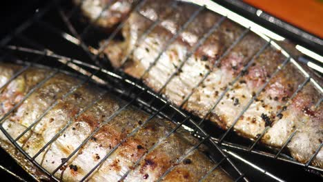 tasty whole fishes placed on barbecue grill