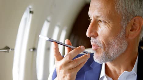 businessman talking on mobile phone while travelling in private jet 4k