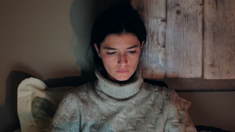 young caucasian woman using laptop in bed, focused and relaxed