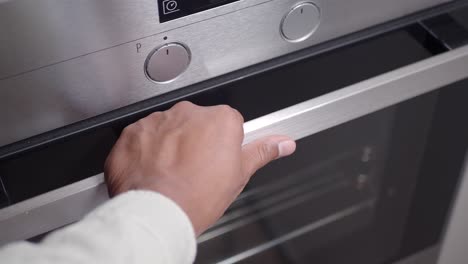 person opening an oven door