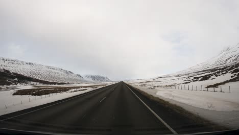 wide pov driving on snowy iceland road in the winter - copy space in sky
