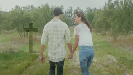 woman and man walking down narrow grassy path in orchard, showing health cross overlay