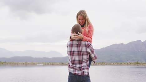 Caucasian-couple-having-a-good-time-on-a-trip-to-the-mountains,-smiling,-the-man-holding-the-woman