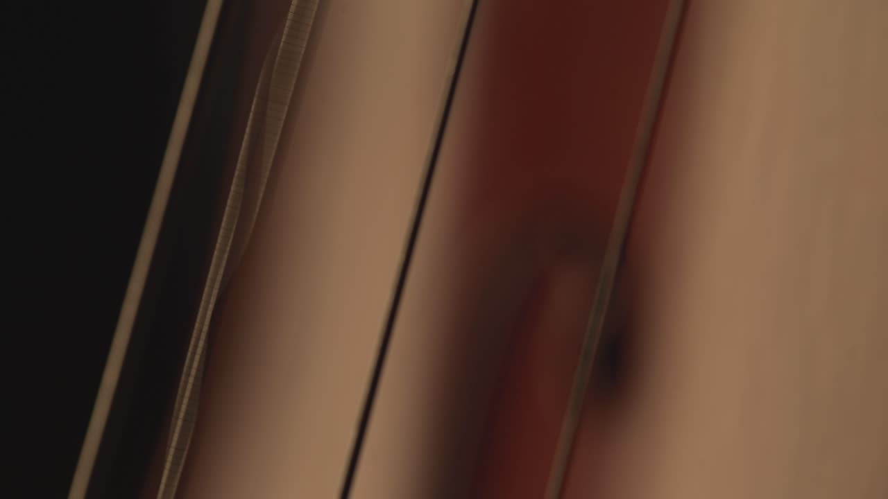 macro primo piano di violoncello, arco per violoncello, violoncello e video musicale di archi, violoncellista