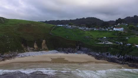 aerial, inclinado hacia arriba, tiro de camión playa de vidiago acampando la paz en la parte superior del acantilado