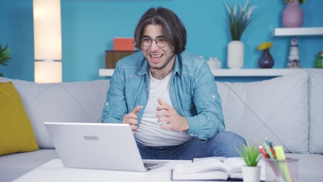 un joven mirando la computadora portátil con entusiasmo.