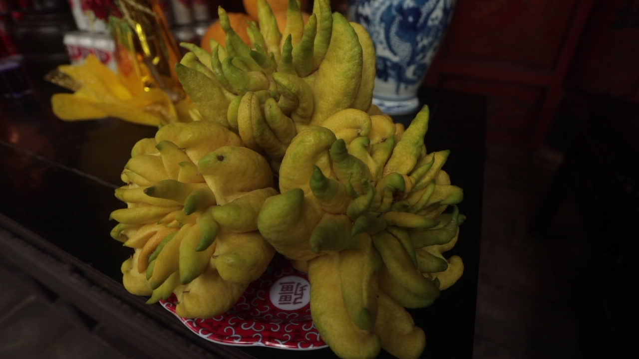 Buddha's hand fruit on a traditional altar in Sa Pa, Vietnam with intricate vases and offerings