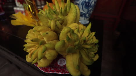 buddha's hand fruit on a traditional altar in sa pa, vietnam with intricate vases and offerings