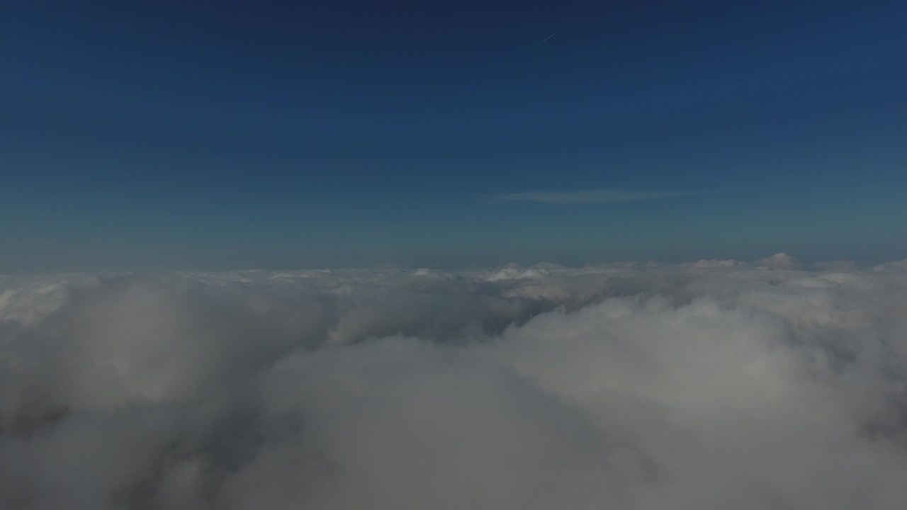 volando sobre las altas montañas en hermosas nubes. vista aérea.