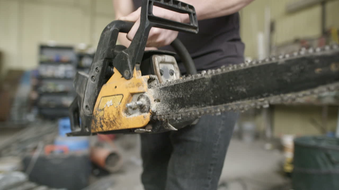 Young Craftsman Starting Powered Chainsaw In Workshop 2