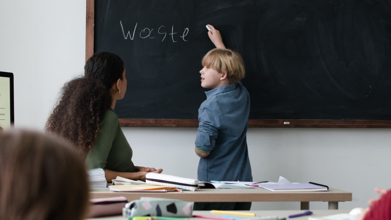 Student writing on chalkboard in class