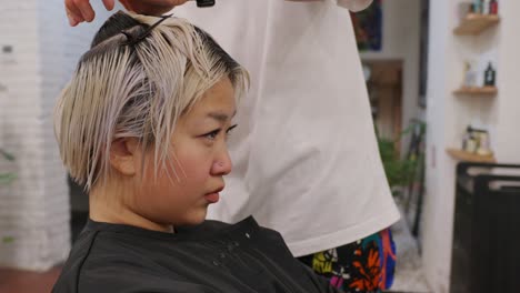 woman getting her hair dyed and cut at a salon