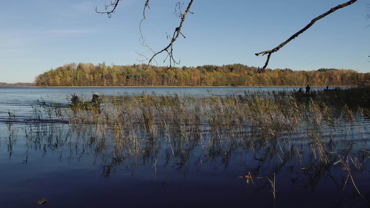 People in a Lake Surrounded by Reeds in Autumn