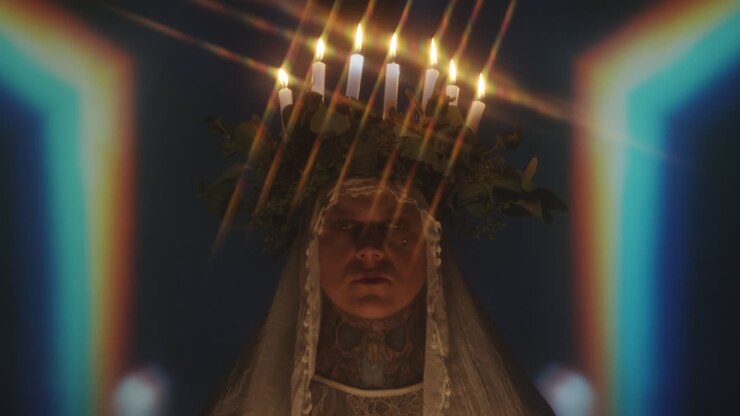 Man Wearing Candle Lit Wreath and Veil
