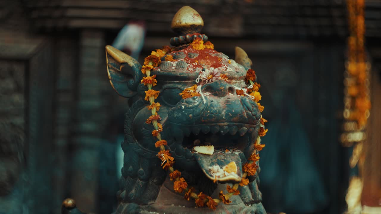 Bhairavnath Tapınağı'nda tütsü ve çiçek çelenkleriyle süslenmiş aslan heykeli, Nepal