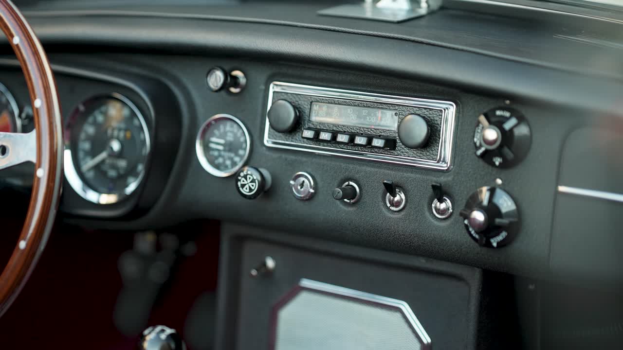 Nahaufnahme des Armaturenbretts eines Oldtimers mit Radioanzeigen und Schaltern MG-Wagen