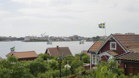 National-Day-in-Sweden,-Flags-and-Red-Summer-Houses,-Celebration-scene