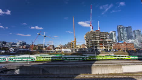 Zeitraffer-Der-Skyline-Von-Toronto,-Beobachten-Sie-Die-Vorbeifahrenden-Züge-Und-Autos,-Während-Krane-Neue-Klammern-Der-Aufkeimenden-Skyline-Errichten