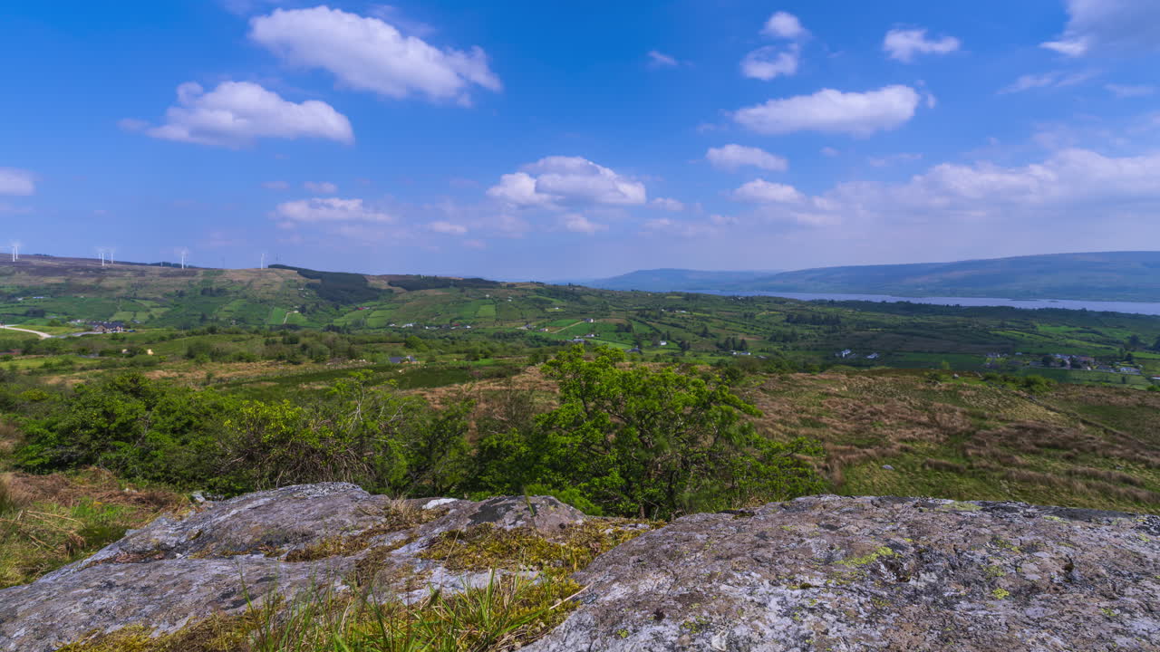 Time lapse of rural landscape with rocky foreground and hills and lake in the distance on a spring sunny day in Arigna mountains in county Leitrim in Ireland