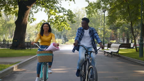 couple enjoying a bike ride in a park with flowers