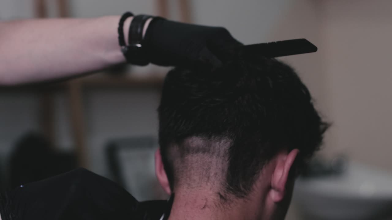 peluquero cortando el pelo de una persona en una barbería