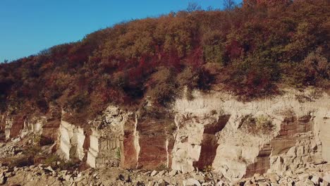 view of a large sand quarry with stones and forest. Professional equipment works for the extraction of sand. Camera motion left