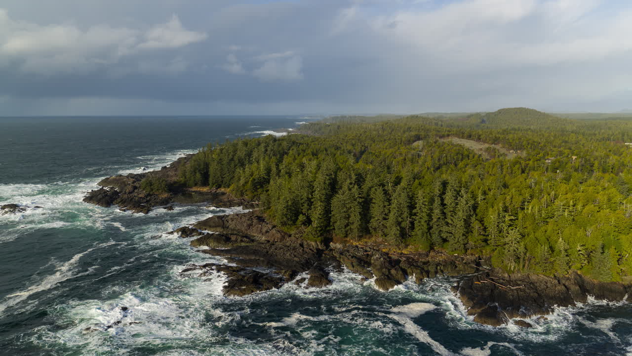 Video drone saat matahari terbenam di Ucluelet, British Columbia, Kanada, di atas samudra dan hutan.