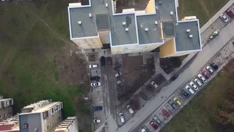 flying over a concrete living apartment area in east europa with many birds flying around the drone